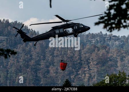 Mezni Louka, Tschechische Republik. 31.. Juli 2022. Hubschrauber der slowakischen Armee Sikorsky UH-60 Black Hawk mit Schaufelfliege in der Nähe von Mezni Louka im Nationalpark der Tschechischen Schweiz, Tschechische Republik, 31. Juli 2022. Das Feuer im Nationalpark Tschechische Schweiz dauert seit acht Tagen an. Quelle: Ondrej Hajek/CTK Photo/Alamy Live News Stockfoto