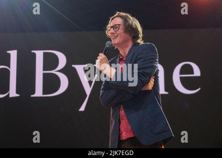 Der irische Schauspieler und Komiker Edward Cathal Byrne alias Ed Bryne, der auf dem Big Top, dem Camp Beestival Familienfestival, eine Comedy-Skizze aufführt. Edward Cathal Byrne ein irischer Schauspieler und Komiker. Er hat die britischen Fernsehserien nur für Lacher und Uncut präsentiert! Best Unseen Ads, war Gast bei zahlreichen TV-Panelspielen und war bereits in einer Reihe von TV-Kochshows zu sehen. Er entschied sich, Gartenbau an der University of Strathclyde in Glasgow zu studieren und wurde in seinem zweiten Studienjahr zum Entertainments Convener bei der Students' Union berufen. Byrne startete eine Comedy-Nacht namens The Comedy Cellar i Stockfoto