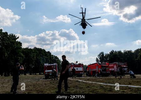 Mezni Louka, Tschechische Republik. 31.. Juli 2022. Der slowakische Hubschrauber bringt Wasser aus einem speziellen 54,5-Kubikmeter-Beutel, der sich in der Nähe des Feuers befindet und von Tankern in der Nähe von Mezni Louka, Hrensko, im Nationalpark Ceske Svycarsko (Tschechische Schweiz), Tschechische Republik, gefüllt wird, in den Eimer, 31. Juli 2022. Das Feuer im Nationalpark Tschechische Schweiz dauert seit acht Tagen an. Quelle: Ondrej Hajek/CTK Photo/Alamy Live News Stockfoto