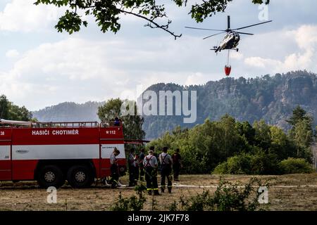 Mezni Louka, Tschechische Republik. 31.. Juli 2022. Der slowakische Hubschrauber bringt Wasser aus einem speziellen 54,5-Kubikmeter-Beutel, der sich in der Nähe des Feuers befindet und von Tankern in der Nähe von Mezni Louka, Hrensko, im Nationalpark Ceske Svycarsko (Tschechische Schweiz), Tschechische Republik, gefüllt wird, in den Eimer, 31. Juli 2022. Das Feuer im Nationalpark Tschechische Schweiz dauert seit acht Tagen an. Quelle: Ondrej Hajek/CTK Photo/Alamy Live News Stockfoto