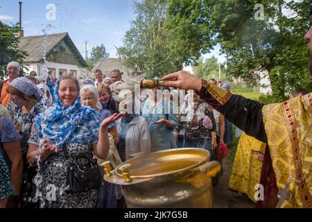 Tutaev Stadt, Jaroslawl Region, Russland. 31., Juli 2022. Während einer religiösen Prozession mit der Ikone des Allbarmherzigen Erlösers in der Stadt Tutayev besprengt ein Priester die Gläubigen mit heiligem Wasser. Die Prozession findet jährlich am Tag der Einweihung der Auferstehungskathedrale, dem zehnten Sonntag nach dem orthodoxen Osterfest, statt, um die Wiedergewinnung der Ikone des Allerbarmers im Jahr 1793 aus der Stadt Rostow Weliki, wo die Ikone 44 Jahre lang geblieben war, zu feiern. Nikolay Vinokurov/Alamy Live News Stockfoto