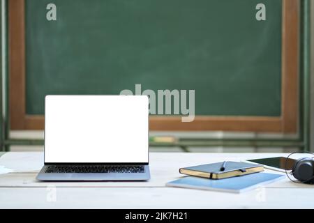 Laptop-Bildschirm auf dem Schreibtisch des Lehrers im Hintergrund der Schule nachmachen. Online-Lernen Stockfoto