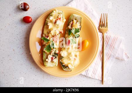 Gefüllte gebackene Zucchini mit Fleisch, Mozzarella, Tomaten, Petersilie. Gesundes Herbstgericht. Ukrainisches Essen Stockfoto