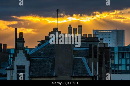 Leith, Edinburgh, Schottland, Großbritannien, 31.. Juli 2022. UK Wetter: Sommeruntergang über Leith: Die Sonne geht über den Dächern von Leith mit der Chancelot-Mühle in der Ferne unter Stockfoto