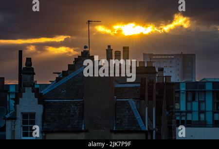 Leith, Edinburgh, Schottland, Großbritannien, 31.. Juli 2022. UK Wetter: Sommeruntergang über Leith: Die Sonne geht über den Dächern von Leith mit der Chancelot-Mühle in der Ferne unter Stockfoto