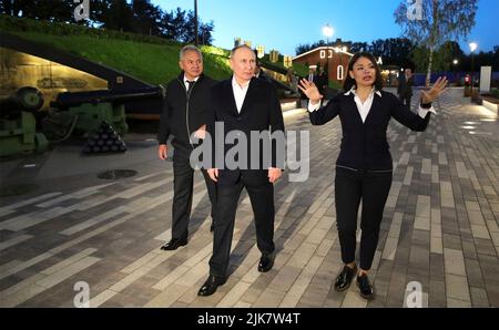 St. Petersburgh, Russland. 31. Juli 2022. Der russische Präsident Wladimir Putin, Zentrum, und Verteidigungsminister Sergei Shoigu, links, werden von der Projektmanagerin Ksenia Shoigu, rechts, im Tourismus- und Erholungscluster Insel Forts am 30. Juli 2022 in Kronstadt, Russland, eine Führung durch das Museum und den Historienpark gegeben. Quelle: Mikhail Klimentyev/Kremlin Pool/Alamy Live News Stockfoto