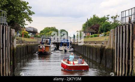 Molesey Lock an der Themse in der Nähe von Hampton Court mit Booten, die durch die offenen Schleusentore in die Schleusenkammer eintreten Stockfoto