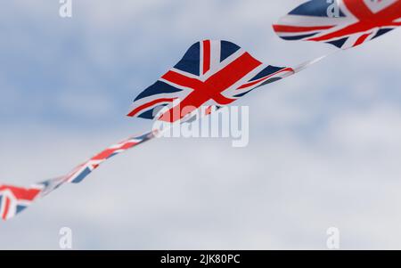 Union Jack, der Flaggen im Wind mit einem Himmelshintergrund anlegt Stockfoto