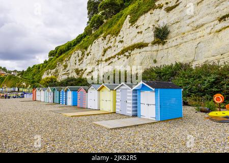 Eine Reihe von Strandhütten am Fuße der Kreidefelsen bei Beer, einem kleinen Küstendorf an der Lyme Bay an der Jurassic Coast of East Dorset, Südwestengland Stockfoto