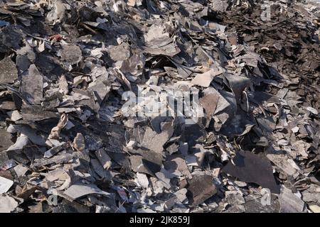 Stapel von ausrangierten Asphaltdachschindeln in der Recyclinganlage. Stockfoto