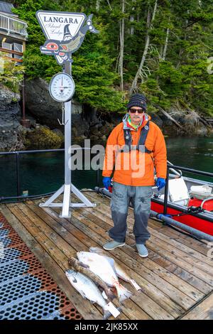 Langara Island, British Columbia, Kanada - 1. Juni 2022: Angelführer mit Fang des Tages auf dem Yachthafen und Dock der Langara Fishing Lodge Stockfoto