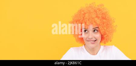 Verträumte freaky Frau in lockigen Clown Perücke Stellen Sie sich etwas vor, Phantasie. Frau isoliert Gesicht Porträt, Banner mit Kopieplatz. Stockfoto