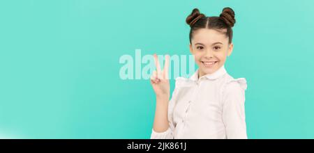 Friedensstifter. Kinder im Schulalter zeigen V-Schild. Happy Kid blauen Hintergrund. Kindergesicht, horizontales Poster, Teenager-Mädchen isoliertes Porträt, Banner mit Kopie Stockfoto