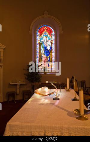 Altartisch und Buntglasfenster mit religiöser Figur, Kirche Saint-Francois-de-Sales, Laval, Quebec, Kanada. Stockfoto