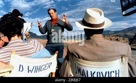 Debra Winger, Bernardo Bertolucci & John Malkovich Film: The Sheltering Sky (UK/IT 1990) / Literaturfilmung (nach dem Buch von Paul Bowles) Regie: Bernardo Bertolucci 25. Oktober 1990 **WARNUNG** Dieses Foto ist nur für redaktionelle Zwecke bestimmt und unterliegt dem Copyright von WARNER BROS. Und/oder des Fotografen, der von der Film- oder Produktionsfirma beauftragt wurde und nur durch Publikationen im Zusammenhang mit der Bewerbung des oben genannten Films reproduziert werden kann. Eine obligatorische Gutschrift an WARNER BROS. Ist erforderlich. Der Fotograf sollte auch bei Bekanntwerden des Fotos gutgeschrieben werden. Ohne schriftliche Genehmigung kann keine kommerzielle Nutzung gewährt werden Stockfoto