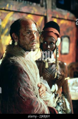 John Malkovich & Iman Film: Heart of Darkness (TV-Film) Charaktere: Kurtz & Black Beauty USA 1993, / Literaturverfilmung (nach dem Buch von Joseph Conrad) Regie: Nicolas Roeg 01. Oktober 1993 **WARNUNG** Dieses Foto ist nur für redaktionelle Verwendung bestimmt und unterliegt dem Copyright von TURNER PICTURES und/oder des Fotografen, der von der Film- oder Produktionsfirma beauftragt wurde und darf nur von Publikationen im Zusammenhang mit der Bewerbung des oben genannten Films reproduziert werden. Eine obligatorische Gutschrift für TURNER-BILDER ist erforderlich. Der Fotograf sollte auch bei Bekanntwerden des Fotos gutgeschrieben werden. Ohne eine kommerzielle Nutzung kann keine Verwendung gewährt werden Stockfoto
