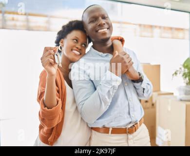 Glückliche Hausbesitzer. Ein junges Paar zeigt die Schlüssel zu ihrem neuen Haus. Stockfoto