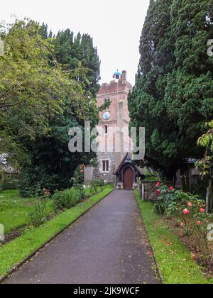 Ein Bürgersteig führt zur historischen St. Mary the Virgin Church in Harmondsworth, Hillingdon, Middlesex, London, England, VEREINIGTES KÖNIGREICH. Stockfoto