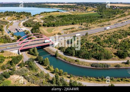 19. Juli 2022, Sachsen, Störmthal: Blick auf den geschlossenen Störmthal-Kanal zwischen Störmthal-See (Vorderseite) und Markkleeberg-See. Das Ziel eines Wasserstraßennetzes, das mit Booten aus den überschwemmten ehemaligen Braunkohlebergwerken südlich von Leipzig schiffbar ist, scheint derzeit noch weit entfernt zu sein. Der etwa 850 Meter lange Störmthaler-Kanal samt Schleuse musste nach Verformungen im Damm geschlossen werden, und es ist ungewiss, ob er wieder geöffnet werden wird. Im Fall des Harth-Kanals zwischen Zwenkauer See und Cospudener See gibt es Fragen zur Finanzierung, und es ist unklar, wann der Bau b erfolgen wird Stockfoto