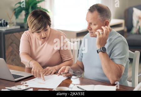 Ich weiß nicht, wie das passiert ist. Ein reifer Mann und Frau gehen über ihre Finanzen zusammen. Stockfoto