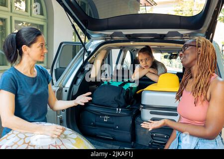 Verschiedene Menschen reisen im Urlaub mit dem Auto, mit Familie und Freunden, um an die Küste mit aufblasbaren und Gepäck zu gehen. Reisen Sie mit dem Auto zum Meer, beladen Sie Gepäck und Taschen. Stockfoto