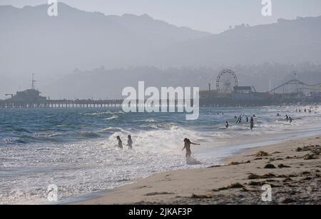 Los Angeles, 12. Juli 2022: Die Menschen genießen die Nachmittagssonne am Venice Beach, Los Angeles, mit nebligen Hügeln im Hintergrund Stockfoto