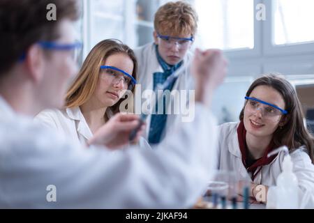 Wissenschaftliche Studenten mit Lehrer machen chemische Experimente im Labor an der Universität. Stockfoto