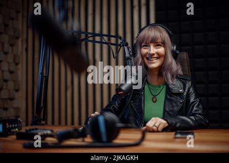 Porträt einer Sprecherin im Radio, die während der Moderation einer Live-Show im Mikrofon spricht Stockfoto