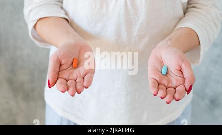 Dilemma Wahl Frau halten rot blaue Kapsel Stockfoto