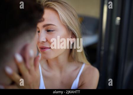 Junges Paar in der Liebe Kuscheln und Küssen im Freien auf der Terrasse, Wochenende in winzigen Haus auf dem Land, nachhaltiges Leben. Stockfoto