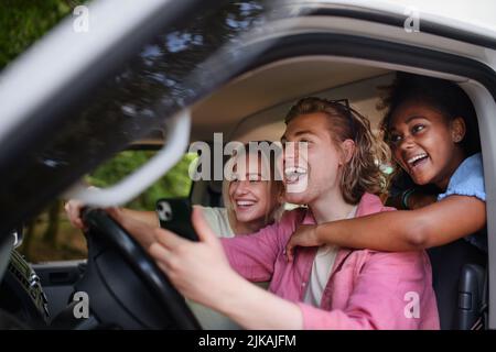 Multirassische junge Freunde, die zusammen mit dem Auto reisen, Spaß haben - Sommerferien, Urlaub, Reisen, Roadtrip und Menschen Konzept. Stockfoto