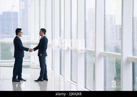 Asiatische Geschäftspartner schütteln sich nach dem Gespräch die Hände Stockfoto