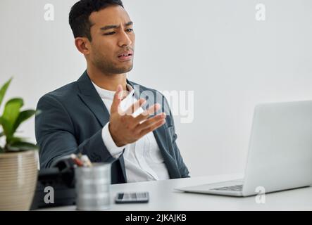 Gerechtigkeit war ein Versprechen des Unehrlichen. Ein Geschäftsmann, der frustriert war, als er seinen Laptop an seinem Schreibtisch in einem modernen Büro benutzte. Stockfoto