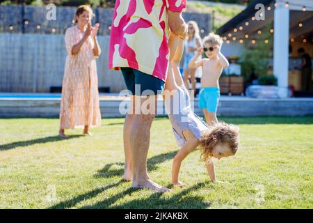 Großvater mit seiner Enkelin, die Spaß auf der Familiengartenparty hat. Stockfoto