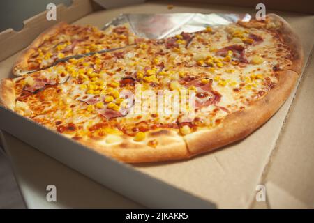 Große Pizzastücke werden in einer offenen Box geliefert Stockfoto