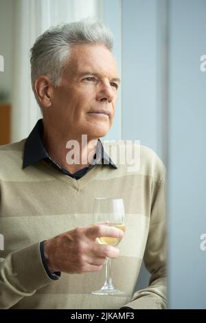 Nachdenklicher reifer, hübscher Mann mit einem Glas Wein Stockfoto