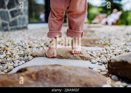 Nahaufnahme von kleinen Mädchen barfuß Beine, erste Schritte im Hinterhof während des Sommers. Stockfoto