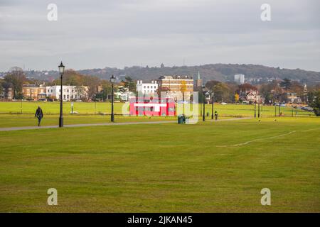 Ein roter Doppeldeckerbus, der durch Blackheath in London, England, fährt Stockfoto