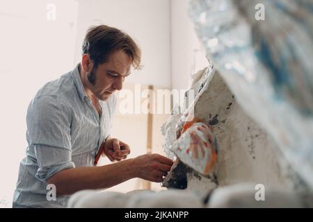 Arbeitsplatz Mosaiken Meister machen Smaltglas Mosaik Panel. Mann Mosaiker bei der Arbeit Stockfoto