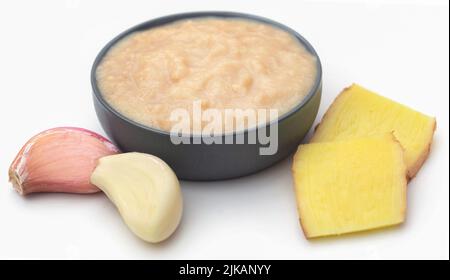 Ingwer und Knoblauch mit Paste auf weißem Hintergrund Stockfoto