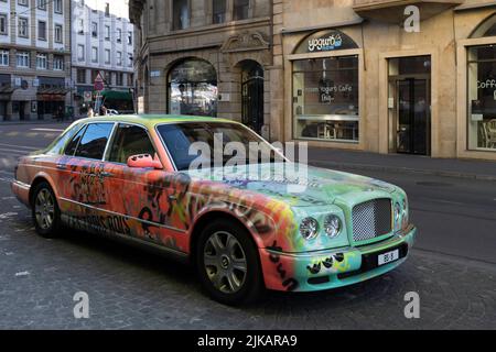 Bunt bemalte und dekorierte klassische Bentley-Luxuslimousine in einer Straße im Zentrum der Schweizer Stadt Basel Stockfoto