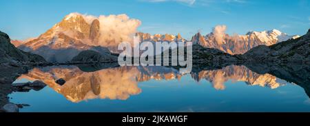 Das Panorama des Mont Blanc Massivs Les Aiguilles Türme, Grand Jorasses und Aiguille du Verte über den Lac Blanc See im Sonnenuntergang Licht. Stockfoto