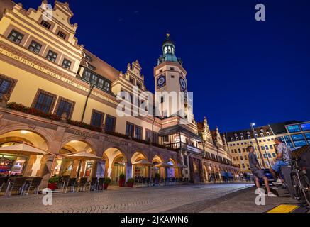 Leipzig, Deutschland - 02. Juli 2022: Die Innenstadt der sächsischen Metropole bei Nacht. Das alte Rathaus oder Rathaus beleuchtet im Sommer. Menschen Stockfoto