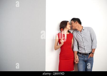 Elegantes asiatisches Paar, das am Valentinstag die Hände hält, um sich zu küssen Stockfoto
