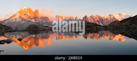 Das Panorama des Mont Blanc Massivs Les Aiguilles Türme, Grand Jorasses und Aiguille du Verte über den Lac Blanc See im Sonnenuntergang Licht. Stockfoto