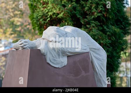 Grabskulptur einer trauernden Figur im weißen Mantel des Lytschakiv Friedhofs in Lwiw, Ukraine Stockfoto
