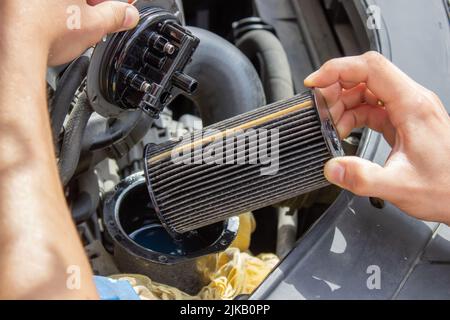 Techniker wechselt den Autofilter und das Autoersatzteil. Car Service Konzept. Selektiver Fokus Stockfoto