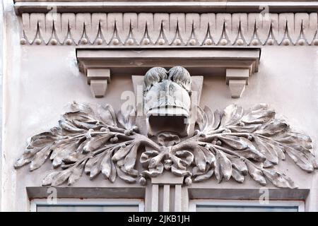 Relief von Helm und Olivenzweigen an der alten Gebäudefassade in Lviv Ukraine Stockfoto