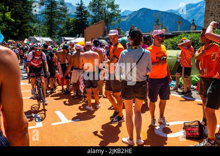 Radsportfans, die die Strecke auf der Alpe d'Huez während der Tour de France 2022 auffahren, und die Fahrer, die durch die Tour fahren Stockfoto