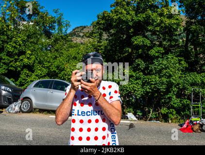 Radsportfans, die die Strecke auf der Alpe d'Huez während der Tour de France 2022 auffahren, und die Fahrer, die durch die Tour fahren Stockfoto